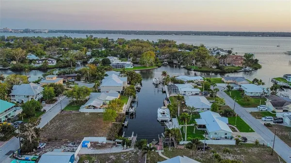 an aerial view of a city with lots of residential buildings ocean and mountain view in back