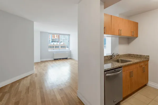 a kitchen with granite countertop a stove and a wooden floors