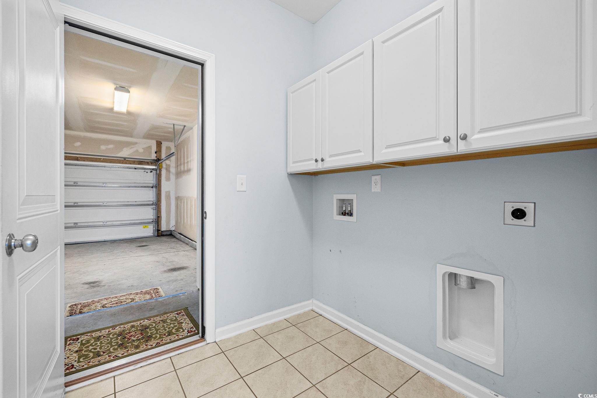 817 Arezzo Way, Unit 1001 Myrtle Beach, SC 29579 - Photo 19 of 40 Laundry area with hookup for a washing machine, a garage, cabinet space, electric dryer hookup, and light tile patterned floors
