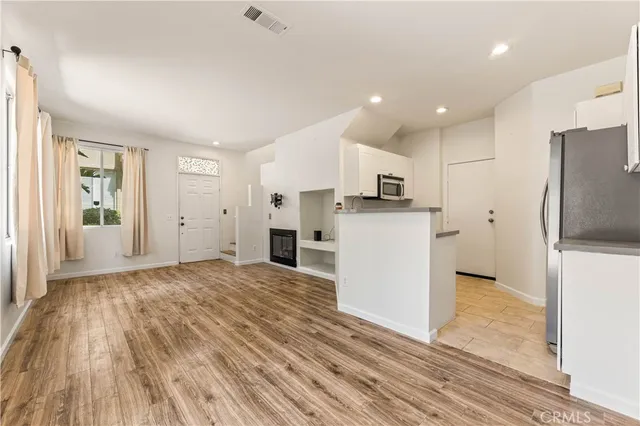 a view of a kitchen with a refrigerator and a stove top oven