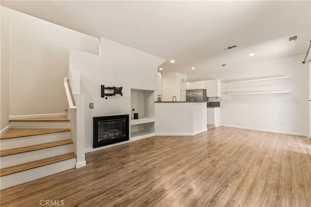 a view of a kitchen with wooden floor and a fireplace
