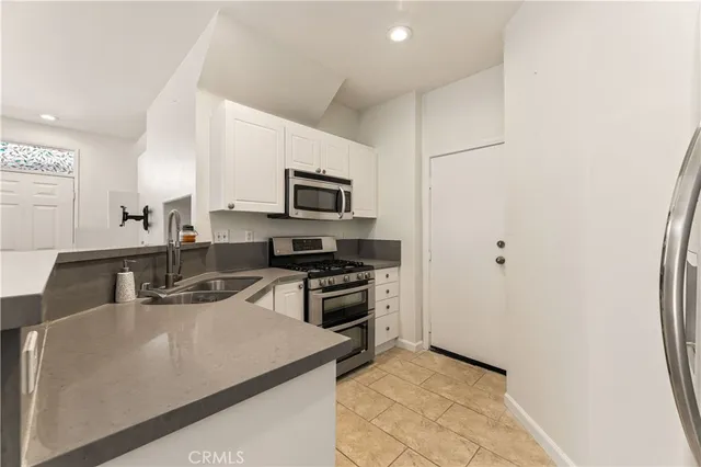 a kitchen with kitchen island a sink appliances and cabinets