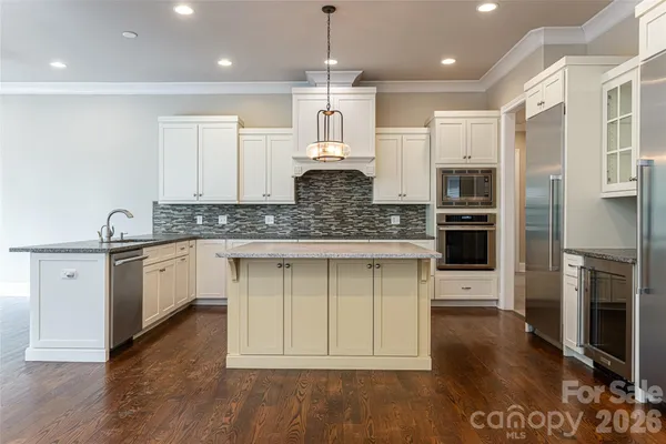 a large kitchen with stainless steel appliances granite countertop a stove a sink and a refrigerator