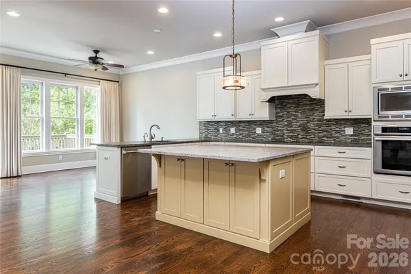 a kitchen with stainless steel appliances kitchen island granite countertop a stove a sink and a microwave