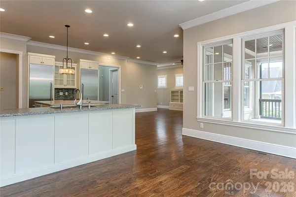 a view of large kitchen with granite countertop a large counter top and stainless steel appliances