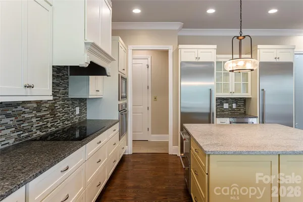 a kitchen with stainless steel appliances kitchen island granite countertop a refrigerator and a sink