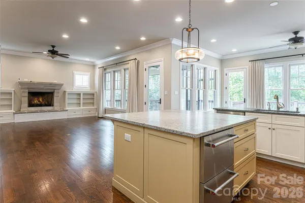 a open kitchen with granite countertop a stove and a wooden floors