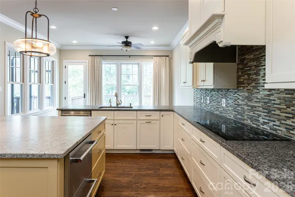 a kitchen with granite countertop a sink and a stove