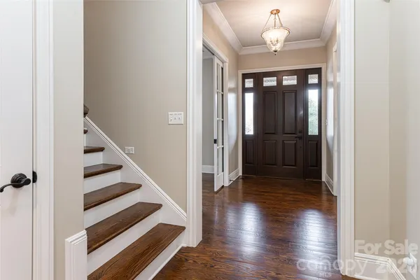 a view of a hallway with wooden floor and staircase