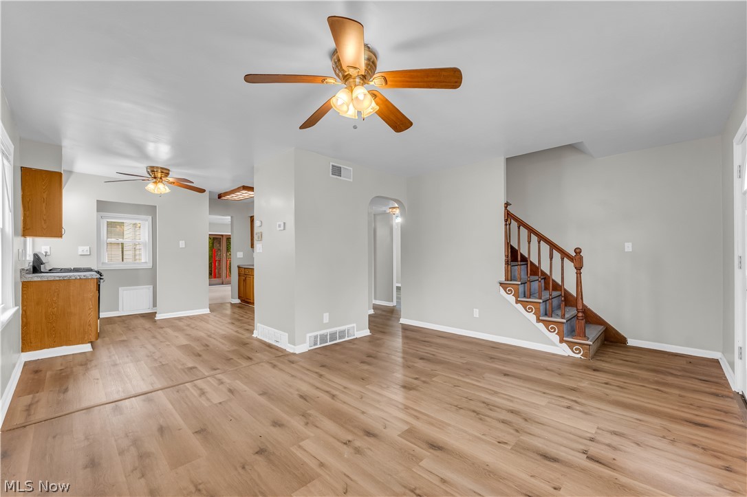18517 Homeway Road Cleveland, OH 44135 - Photo 9 of 29 Open-concept living space featuring wood-finish flooring, light gray wall tones, and multiple ceiling fans