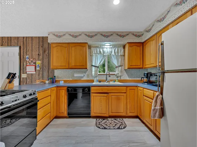 a kitchen with stainless steel appliances granite countertop a stove a sink and a refrigerator