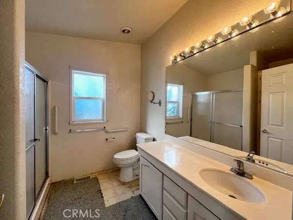 a spacious bathroom with a granite countertop sink toilet and shower
