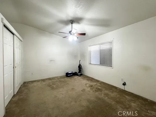 an empty room with fan and windows