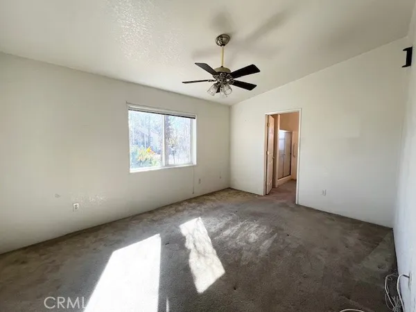 a view of a livingroom with a ceiling fan and window