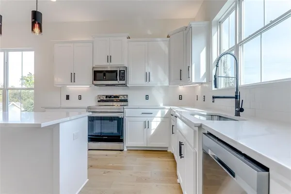 a kitchen with stainless steel appliances a stove sink and cabinets