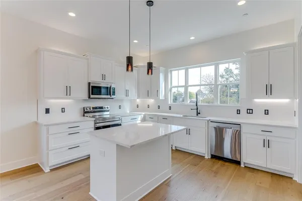 a kitchen with white cabinets and white appliances