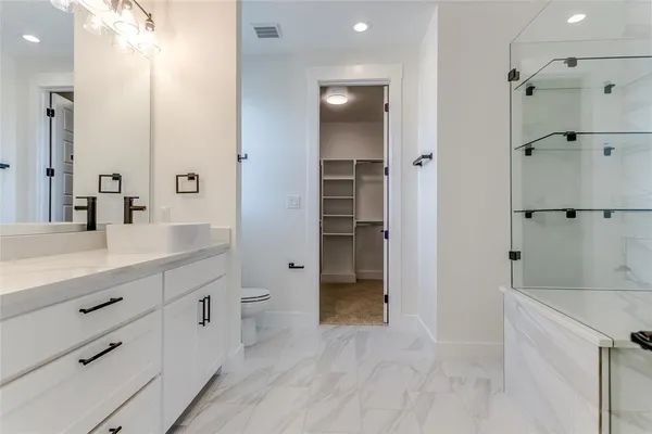 a spacious bathroom with a granite countertop sink mirror and toilet