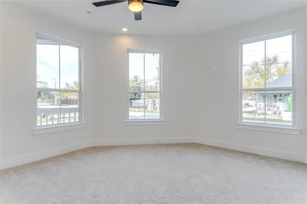 an empty room with a window and ceiling fan