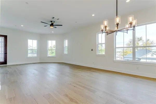 a view of an empty room with a window and wooden floor