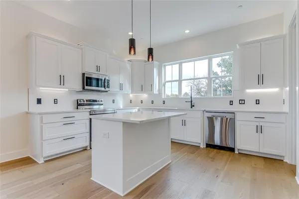 a kitchen with white cabinets appliances and sink