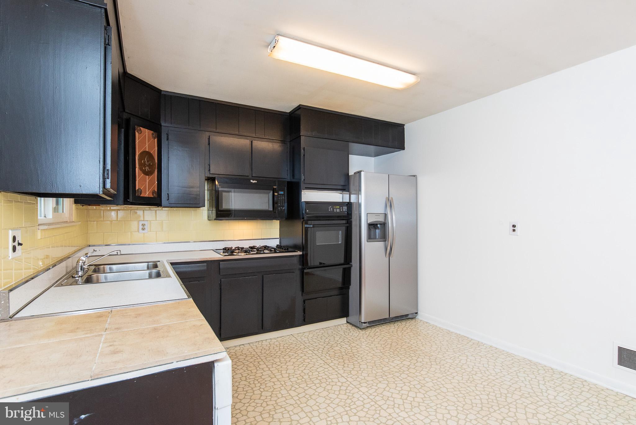 615 Eliot Road Pasadena, MD 21122 - Photo 11 of 43 a kitchen with stainless steel appliances granite countertop a sink stove and refrigerator