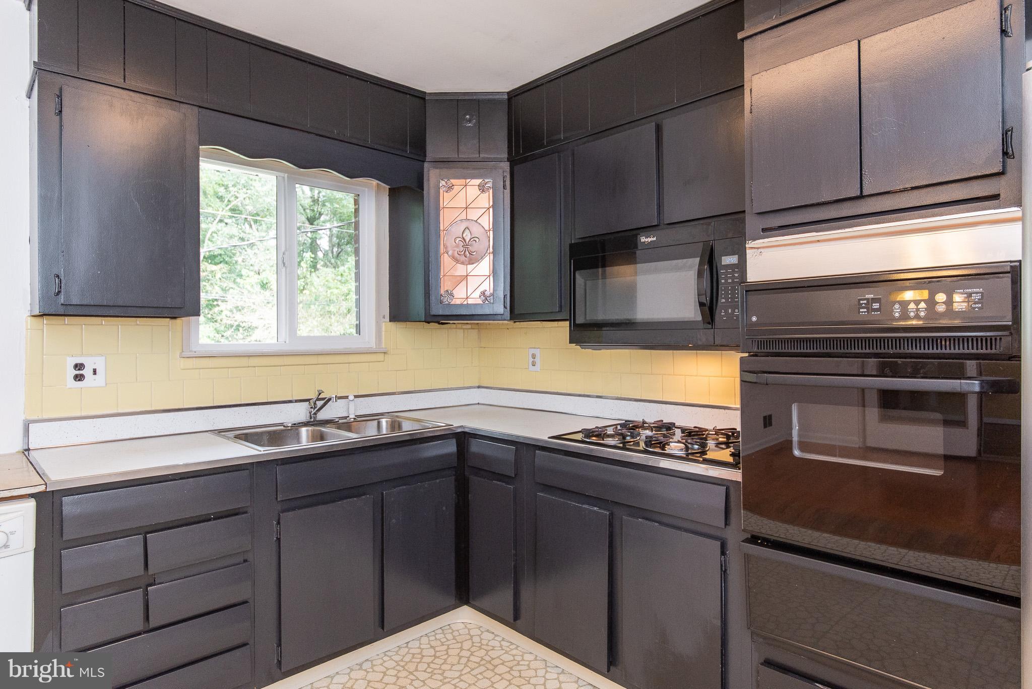 615 Eliot Road Pasadena, MD 21122 - Photo 13 of 43 a kitchen with stainless steel appliances a sink stove and cabinets