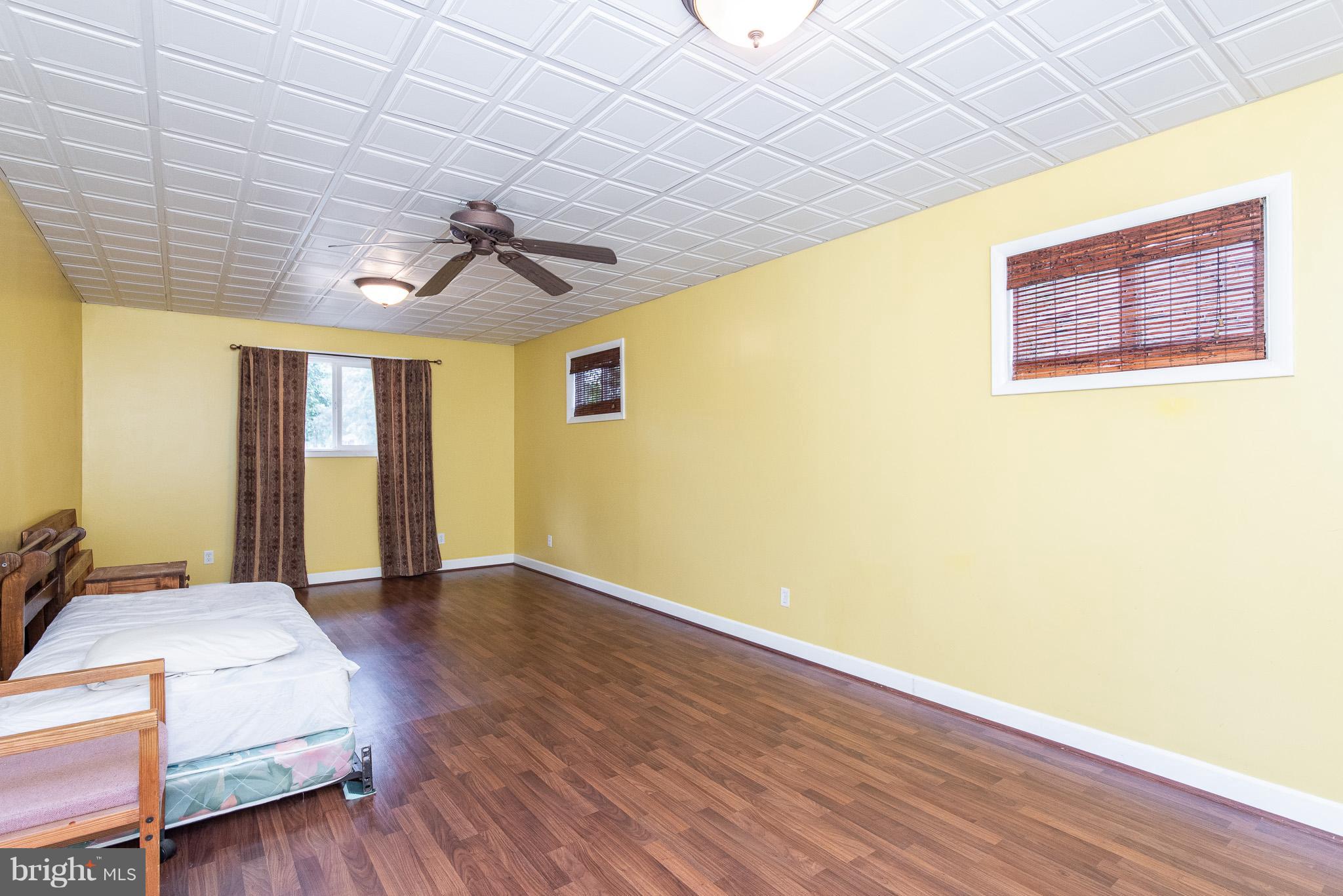 615 Eliot Road Pasadena, MD 21122 - Photo 14 of 43 a spacious bedroom with a bed and wooden floor