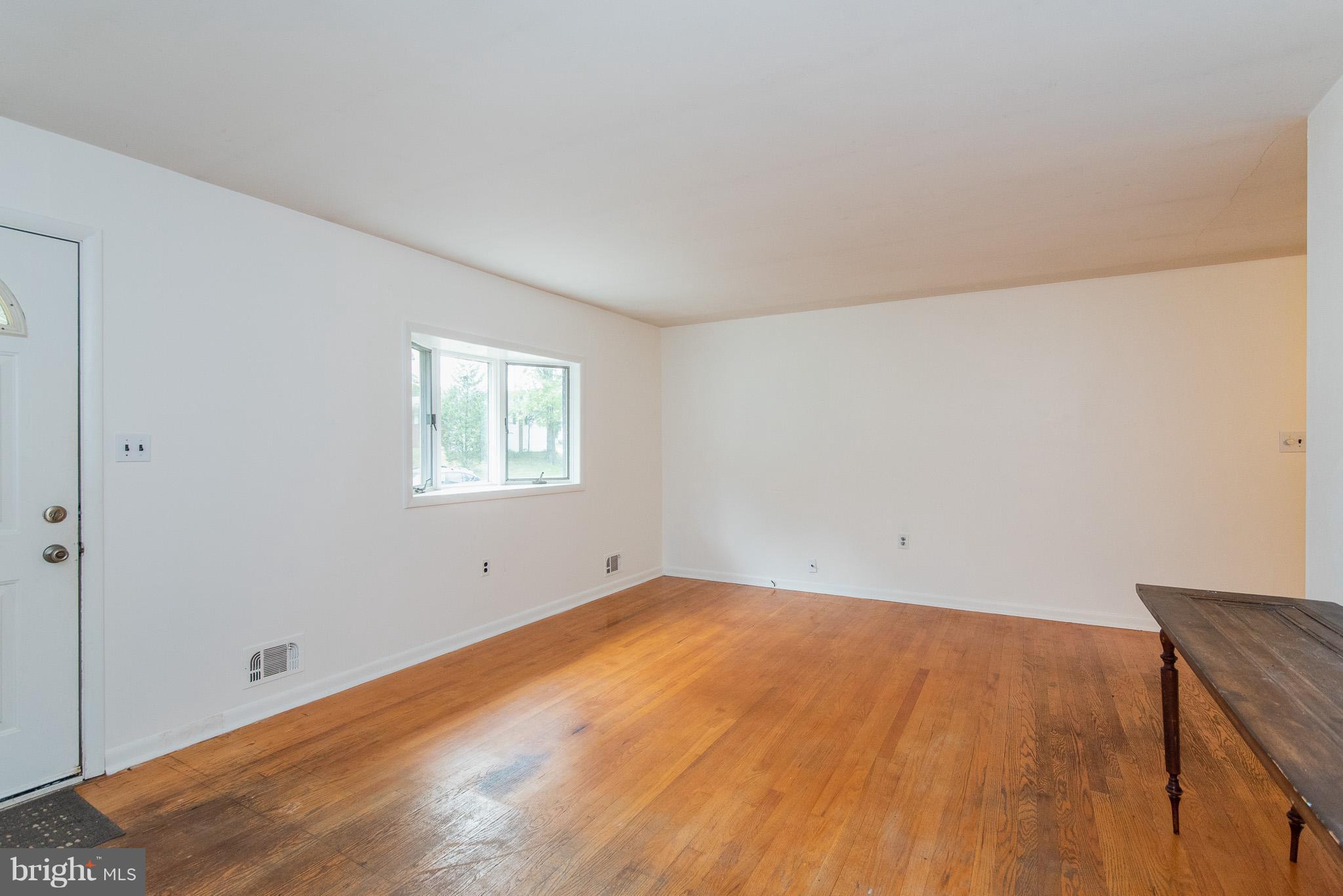 615 Eliot Road Pasadena, MD 21122 - Photo 5 of 43 an empty room with wooden floor and windows
