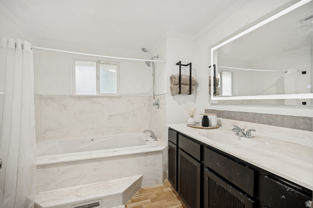 1215 8th Street Ogden, UT 84404 - Photo 20 of 39 Contemporary bathroom featuring a built-in tub with marble-look surround, a dark wood-finish vanity, a single undermount sink, and an illuminated mirror
