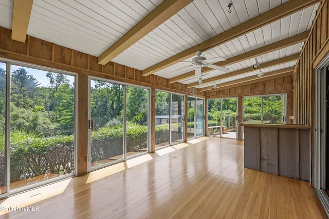 a roof deck with table and wooden floor