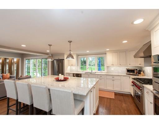117 Forest Street Wellesley, MA 02481 - Photo 12 of 28 a kitchen with stainless steel appliances kitchen island granite countertop a stove a sink a dining table and chairs