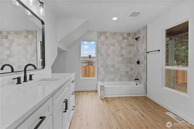 a bathroom with a bathtub a sink a vanity and a shower