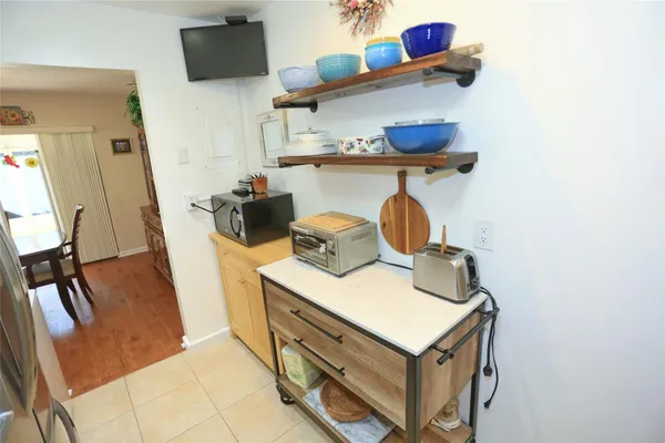 a kitchen with stainless steel appliances a refrigerator a stove a dining table and chairs
