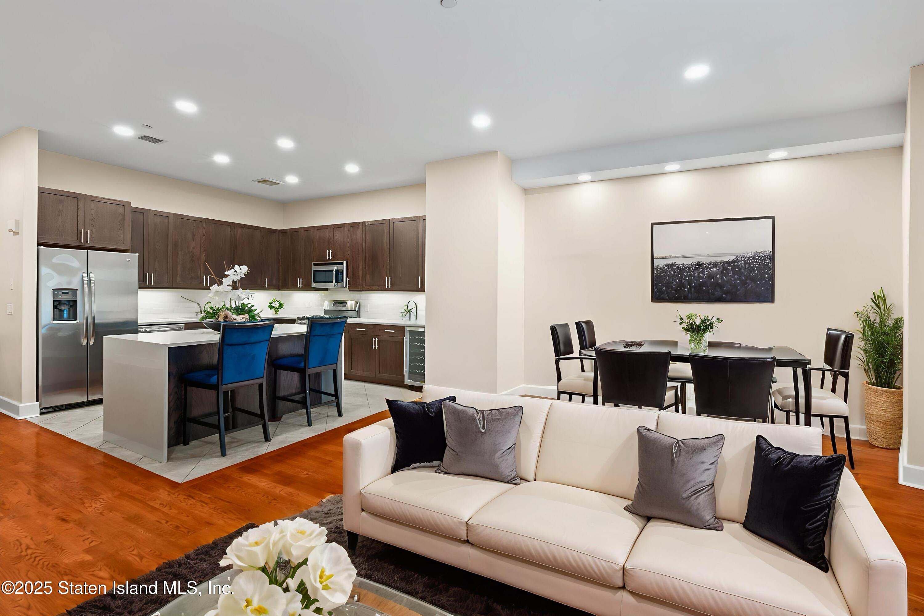 a living room with furniture kitchen view and a flat screen tv