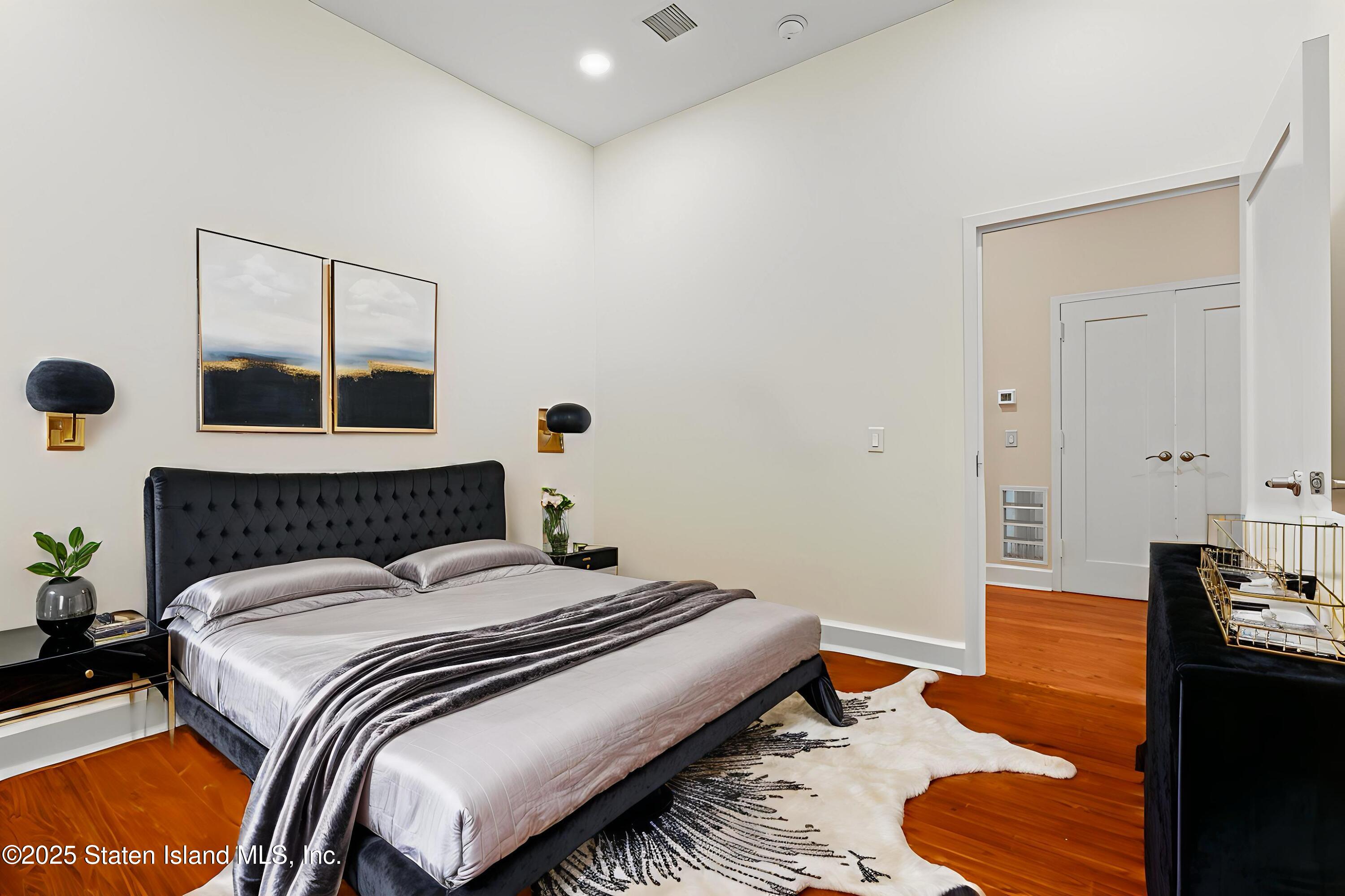 90 Bay Street Landing, Unit 1F Staten Island, NY 10301 - Photo 11 of 55 a bedroom with a bed and wooden floor