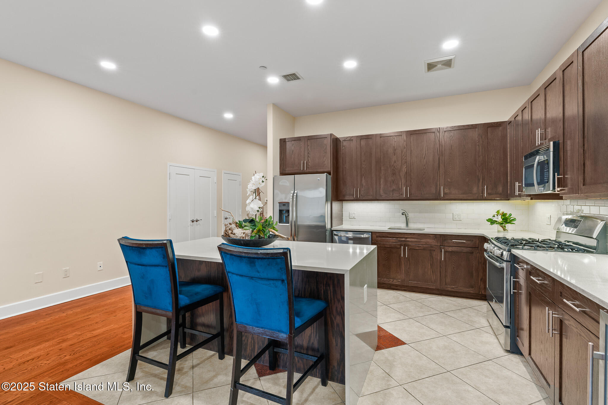 90 Bay Street Landing, Unit 1F Staten Island, NY 10301 - Photo 23 of 55 a kitchen with a sink a microwave and wooden cabinets