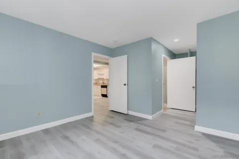 a view of an empty room with wooden floor and closet