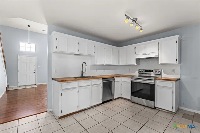 a kitchen with cabinets appliances and a sink