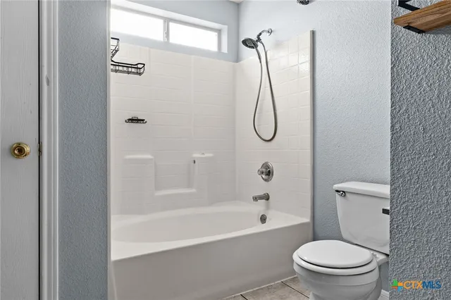a white toilet sitting next to a bath tub shower