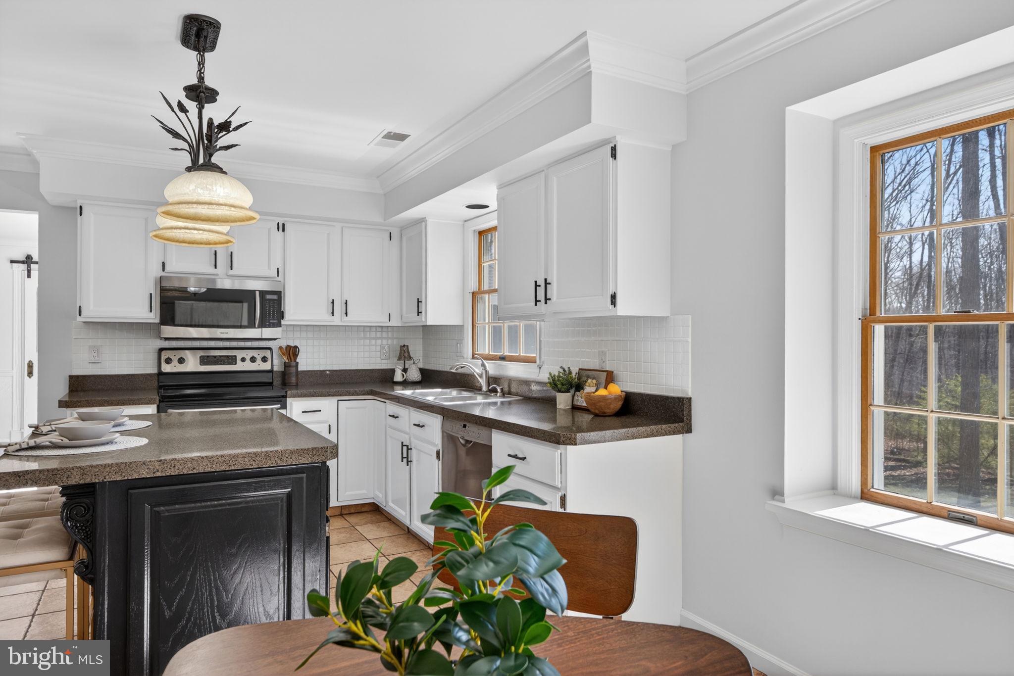 2635 Possum Hollow Road Quakertown, PA 18951 - Photo 47 of 78 a kitchen with stainless steel appliances kitchen island granite countertop a sink a stove cabinets counter space and a window