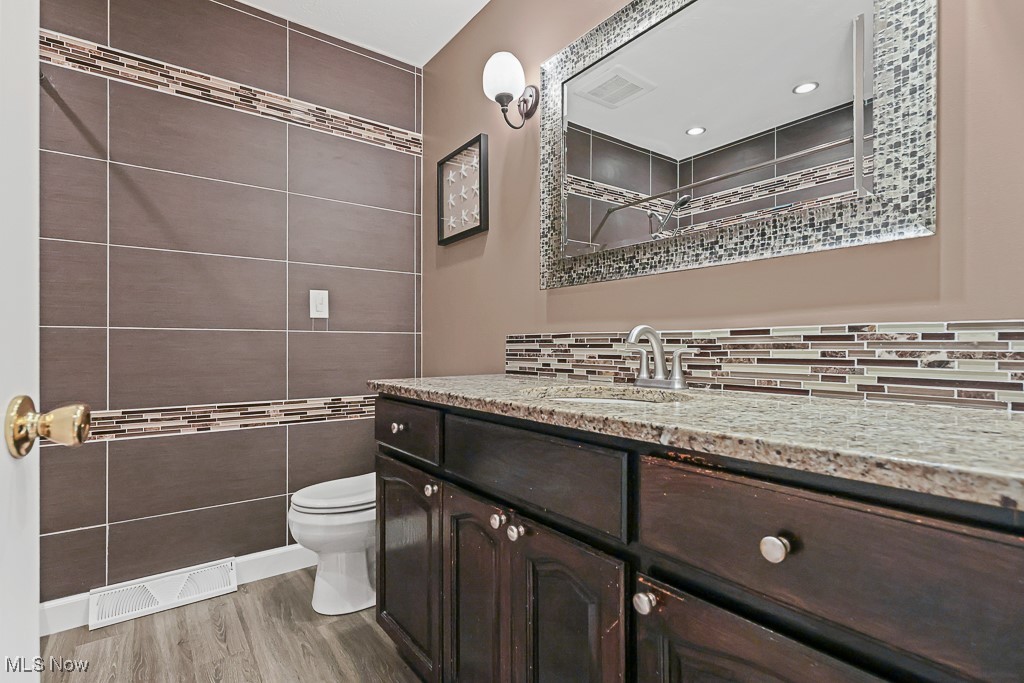 17682 Drake Road Strongsville, OH 44136 - Photo 15 of 45 Bathroom featuring vanity, wood finished floors, and tasteful backsplash