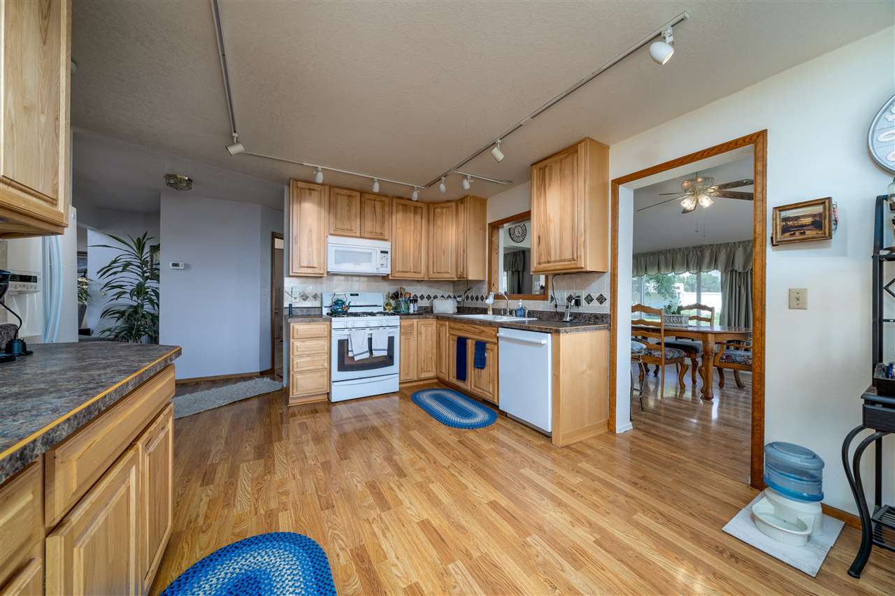 581 34 Road Clifton, CO 81520 - Photo 3 of 42 a kitchen with stainless steel appliances granite countertop a refrigerator a sink dishwasher a stove and a dining table with wooden floor
