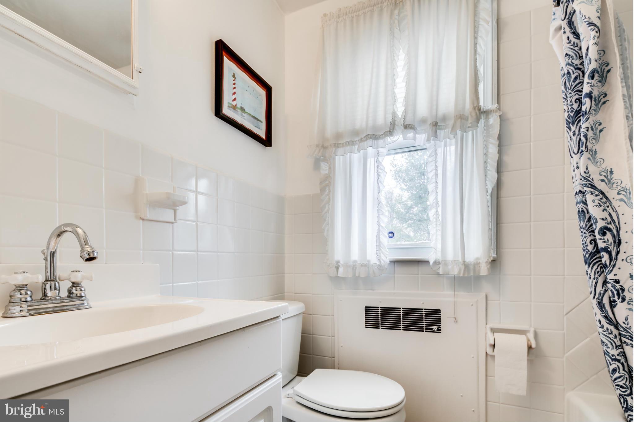732 Warwick Road Baltimore, MD 21229 - Photo 26 of 30 a bathroom with a toilet sink and mirror
