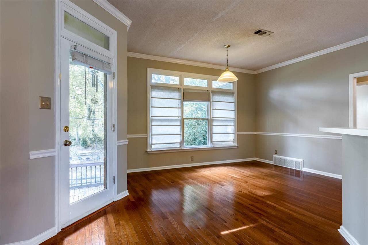 8779 Raspberry Lane Memphis, TN 38016 - Photo 8 of 25 a view of an empty room with wooden floor and a window