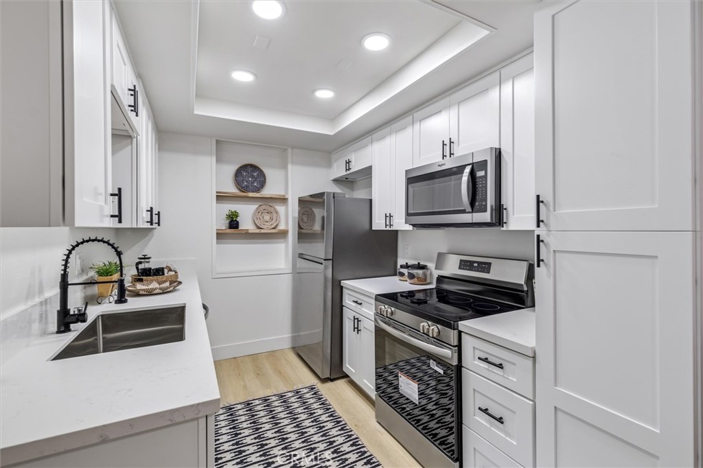 33852 Del Obispo Street, Unit 80 Dana Point, CA 92629 - Photo 2 of 36 a kitchen with stainless steel appliances granite countertop a stove a sink and a microwave