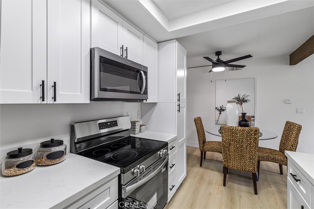 33852 Del Obispo Street, Unit 80 Dana Point, CA 92629 - Photo 7 of 36 a kitchen with stainless steel appliances a stove a sink a microwave and cabinets