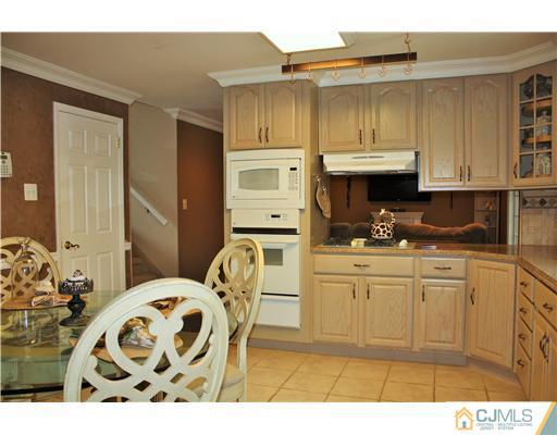 3 Timber Road Edison, NJ 08820 - Photo 8 of 24 a kitchen with stainless steel appliances kitchen island granite countertop a sink a stove a dining table and chairs
