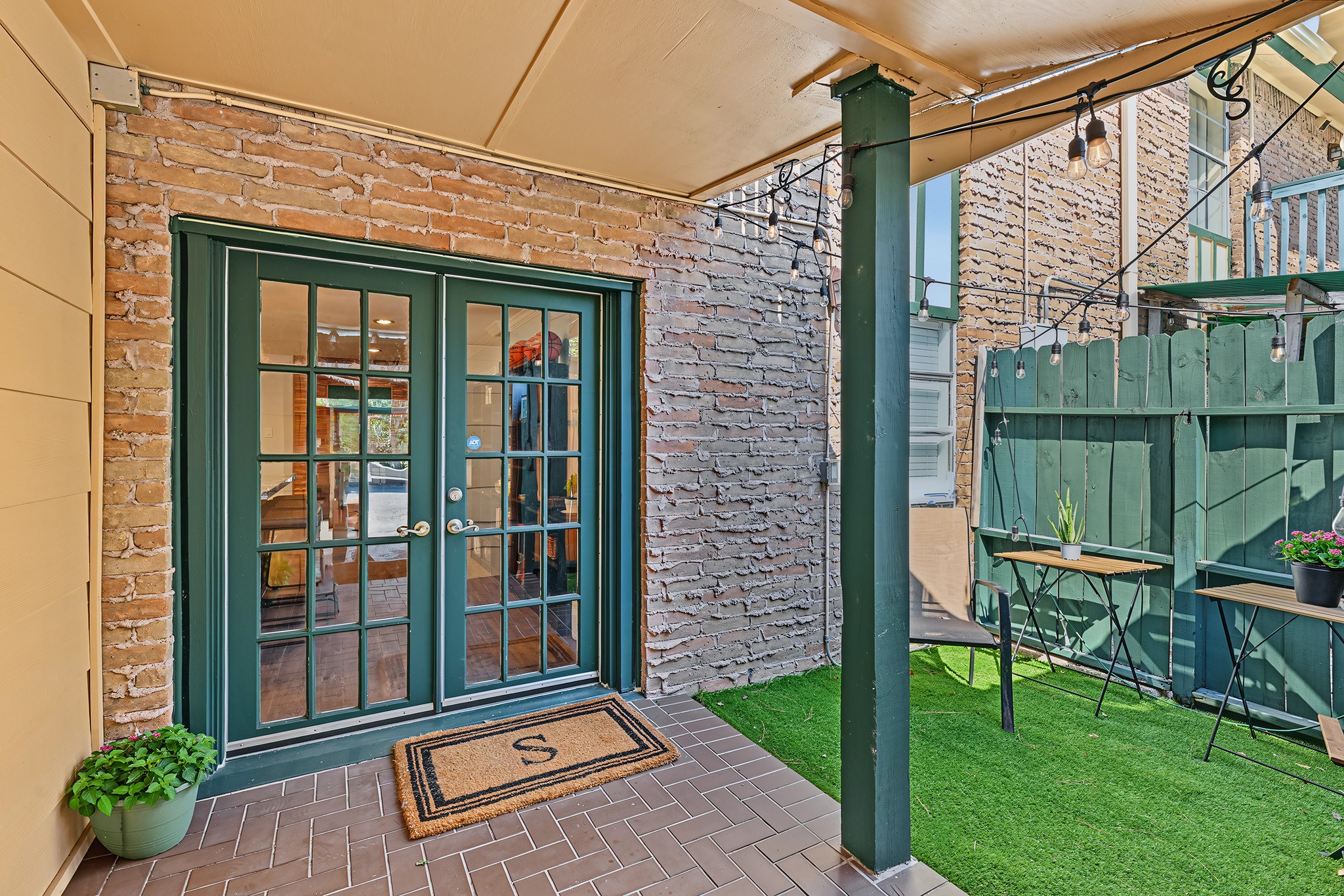 8221 Kingsbrook Road, Unit 108 Houston, TX 77024 - Photo 12 of 18 The back patio features french doors, turf, and fencing for added privacy.