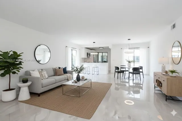 a living room with furniture a chandelier and a potted plant
