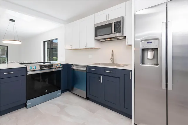 a kitchen with stainless steel appliances granite countertop a refrigerator and a stove top oven